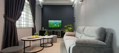 a living room with a couch and a chair and a table at Ipoh Garden East Homestay by Grab A Stay in Ipoh