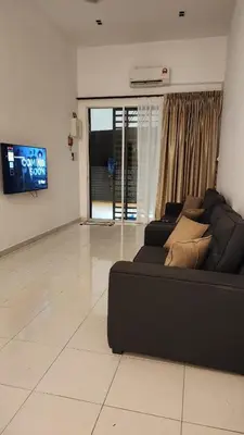 a living room with a black couch and a tv at Masturi Homestay in Chemor
