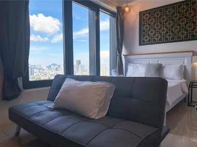 a couch in a room with a bed and a window at Tropicana 218 Macalister by YueLai Inn in George Town