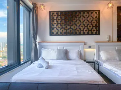 a bedroom with two beds and a large window at Tropicana 218 Macalister by YueLai Inn in George Town