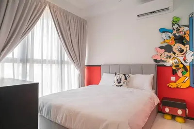 a bedroom with a bed with a red wall at Mickey's Magic Urban Suites Jelutong Penang, Seaview in Jelutong