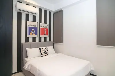a bedroom with a white bed with black and white stripes at Mickey's Magic Urban Suites Jelutong Penang, Seaview in Jelutong