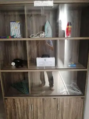 a person standing inside of a wooden book shelf at Simpang Ampat QQ in Simpang Ampat