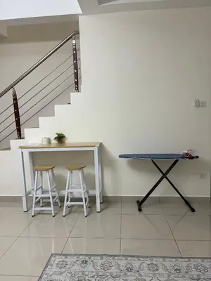 a table and stools in a room with a staircase at AFA Home KKB in Kuala Kubu Baharu