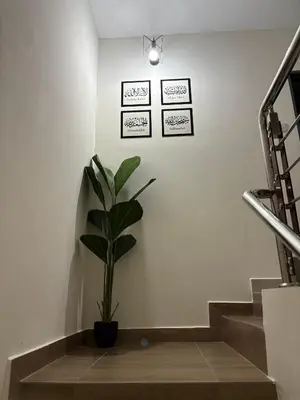 a plant in a pot on a wall with stairs at AFA Home KKB in Kuala Kubu Baharu