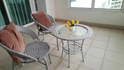 a table with chairs and a vase of flowers on it at Mansion One George Town - Spacious Studio 1 bathroom type in George Town