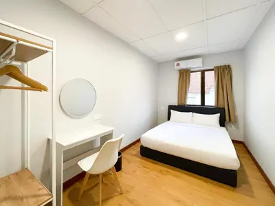 a bedroom with a bed and a desk and a chair at Lili Stay by the beach in George Town