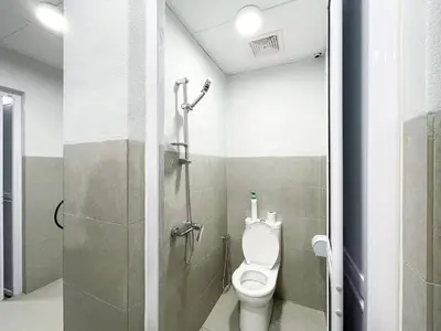 a bathroom with a toilet and a shower stall at Lili Stay by the beach in George Town