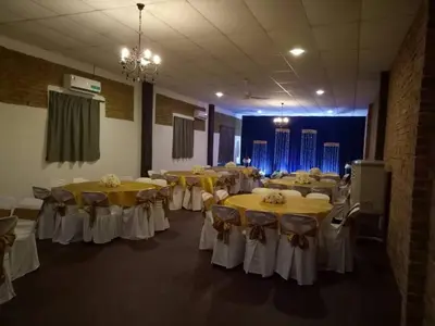 a room full of tables and chairs with yellow and white tables at EFM GREENLAND IPOH in Ipoh