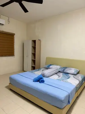 a bedroom with a large bed with blue sheets at Ruzarani Home Meru Suria in Chemor
