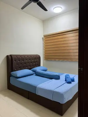 a bedroom with a bed with blue pillows and a ceiling fan at Ruzarani Home Meru Suria in Chemor