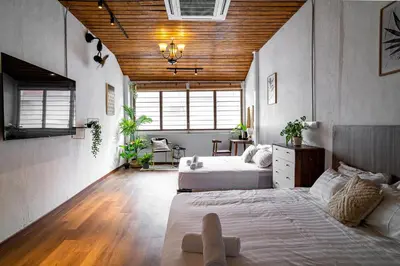 a bedroom with two beds and a wooden ceiling at Caryn Vintage Guesthouse in George Town