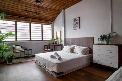 a bedroom with a bed and a large window at Caryn Vintage Guesthouse in George Town