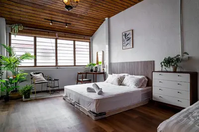 a bedroom with a large bed and a wooden ceiling at Caryn Vintage Guesthouse in George Town