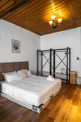 a bedroom with a large bed with a wooden ceiling at Caryn Vintage Guesthouse in George Town