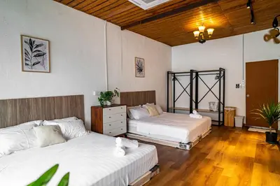 two beds in a room with wooden floors at Caryn Vintage Guesthouse in George Town