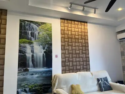 a living room with a waterfall mural on the wall at D Festivo Residences Ipoh in Ipoh