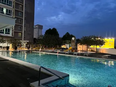 a large swimming pool in a city at night at D Festivo Residences Ipoh in Ipoh