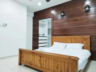 a bedroom with a wooden headboard and a bed at 13Pax -2 Storey Bayu Mutiara Bukit Mertajam Penang in Bukit Mertajam