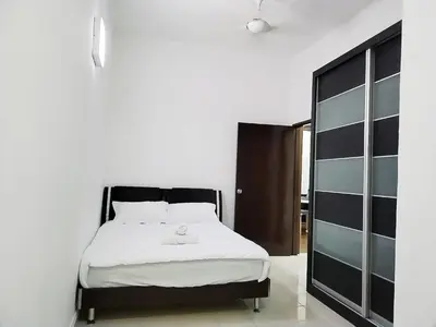 a bedroom with a black and white bed and a mirror at 13Pax -2 Storey Bayu Mutiara Bukit Mertajam Penang in Bukit Mertajam