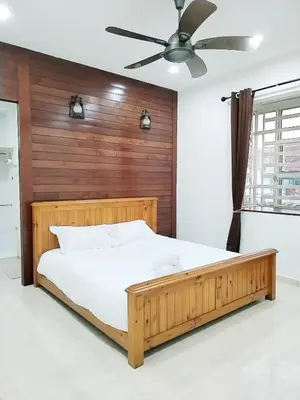 a wooden bed in a room with a ceiling fan at 13Pax -2 Storey Bayu Mutiara Bukit Mertajam Penang in Bukit Mertajam