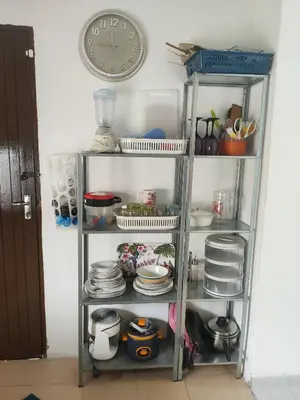 a shelf with dishes and a clock on a wall at CASA AINA at Gopeng Cozy & Comfy Home in Kampong Kepayang