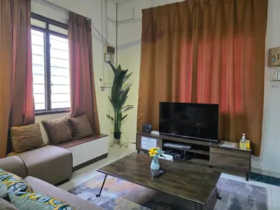 a living room with a couch and a flat screen tv at CASA AINA at Gopeng Cozy & Comfy Home in Kampong Kepayang