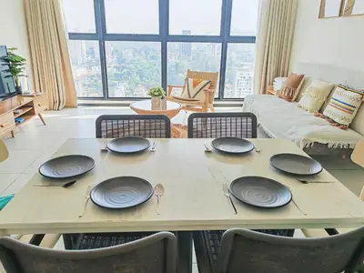 a table with plates on it in a living room at 3410 Home4Stay TownArea NewCozyHome InfinityPool in Jelutong
