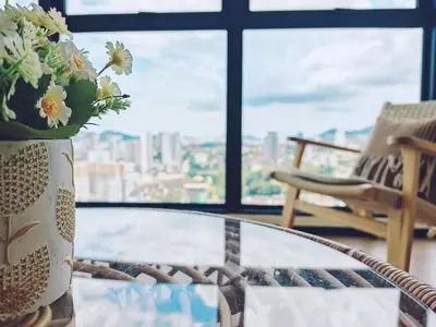 a glass coffee table with a vase of flowers on it at 3410 Home4Stay TownArea NewCozyHome InfinityPool in Jelutong