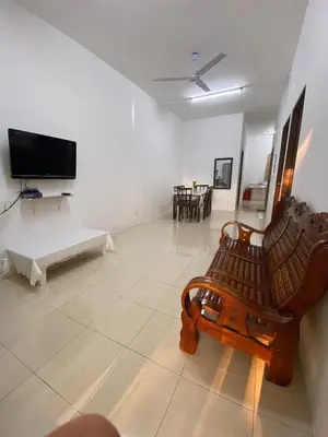a living room with two benches and a tv at EmyNuar Homestay in Batu Kurau