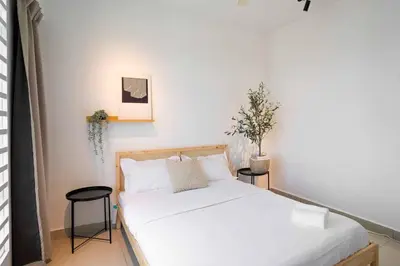 a bedroom with a bed with white sheets and a plant at Chic - 4 bedroom - Projector - Ipoh Town - Sleep8 in Ipoh