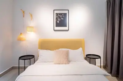 a bedroom with a white bed with two stools at Chic - 4 bedroom - Projector - Ipoh Town - Sleep8 in Ipoh