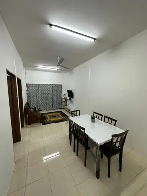 a dining room with a white table and chairs at EmyNuar Homestay in Batu Kurau