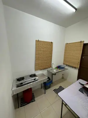 a kitchen with a stove and a sink in it at EmyNuar Homestay in Batu Kurau