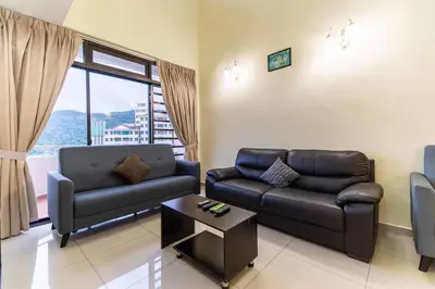 a living room with a couch and a table at Sea View Penthouse Comfy Home at Batu Ferringhi in Batu Ferringhi