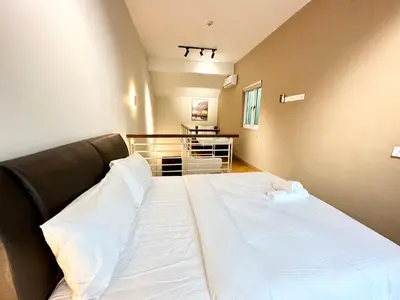 a bedroom with a large bed with white sheets at NAUTILUS HOME AT KARPAL SINGH For 14 PAX in George Town