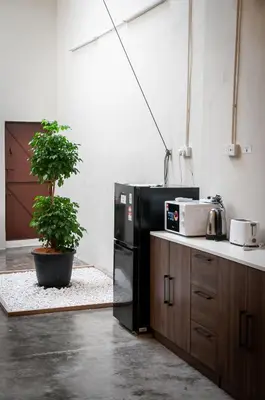 a kitchen with a black refrigerator and a potted plant at Aayu Beach St - George Town Penang in George Town