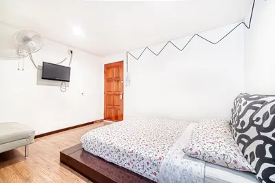 a bedroom with a bed and a flat screen tv at Snooze Hotel in Brinchang
