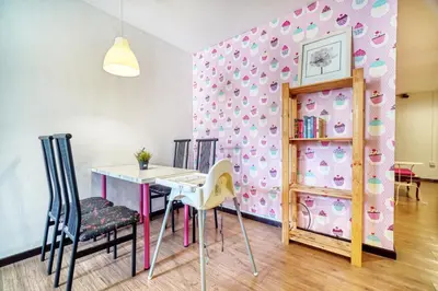 a dining room with a table and chairs and a pink wall at Snooze Hotel in Brinchang