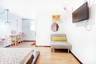 a bedroom with a bed and a tv on a wall at Snooze Hotel in Brinchang