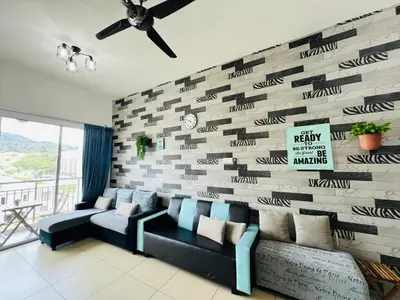 a living room with a couch and a brick wall at Peace Homestay in Cameron Highlands