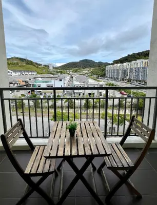 a wooden table and two chairs on a balcony at Peace Homestay in Cameron Highlands