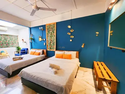 two beds in a room with blue walls at Ipoh Station 18, 4 Bedroom Rainforest LOFT 1 Depan AEON Homestay in Ipoh