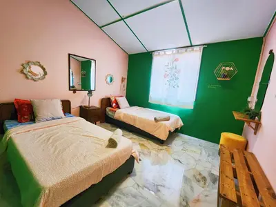 a bedroom with two beds and a green wall at Ipoh Station 18, 4 Bedroom Rainforest LOFT 1 Depan AEON Homestay in Ipoh