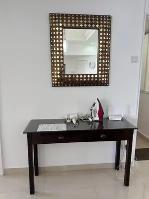 a black desk with a mirror on a wall at Seaview - Sri Sayang in Batu Ferringhi