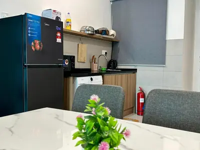 a kitchen with a table and two chairs and a refrigerator at Suite BigStudio @Meritus Residensi in Perai