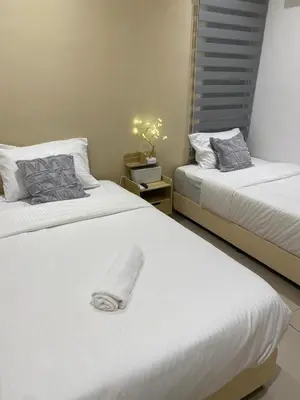 a bedroom with two beds with white sheets at Newly Furnished Metropol Service Apartment with Attractive View in Bukit Mertajam