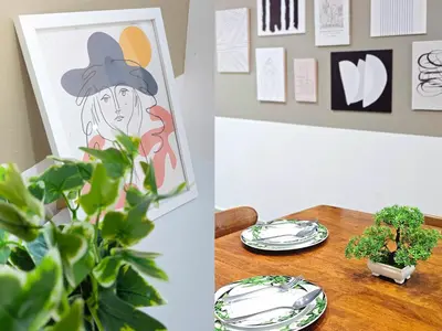 a table with plates and a painting and a plant at Spacious Family 4BR House near Lake Garden Zoo Taiping with Free WiFi and Netflix in Taiping