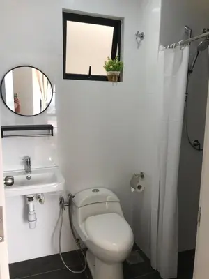 a bathroom with a toilet and a sink and a mirror at Yuru House - The Horizon Ipoh in Ipoh