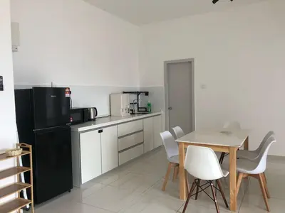 a kitchen with a table and a black refrigerator at Yuru House - The Horizon Ipoh in Ipoh